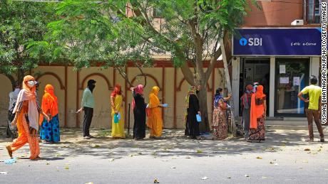 People wait outside a bank during closings in Jaipur, Rajasthan, India, on April 9.