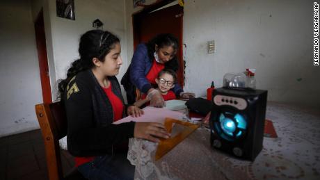 A family listens to an hour's radio lesson from their home in Funza, Colombia, where they have no internet connection.